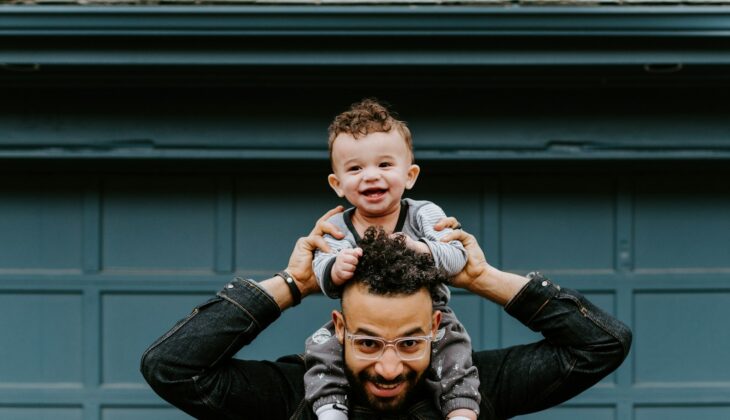 man in black leather jacket carrying boy in black leather jacket